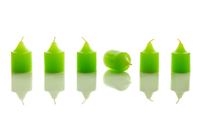 Image showing Row of green candles, with one laying down