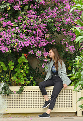 Image showing Teen girl and bougainvillea flowers in garden