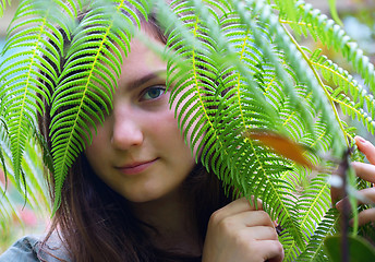 Image showing Teen girl watching through leaves