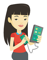 Image showing Woman reharging smartphone from portable battery.