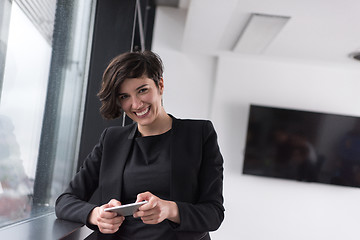 Image showing Elegant Woman Using Mobile Phone by window in office building