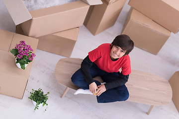 Image showing boy sitting on the table with cardboard boxes around him top vie