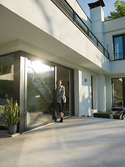 Image showing woman drinking coffee in front of her luxury home villa