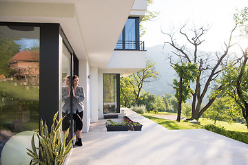 Image showing woman in front of her luxury home villa