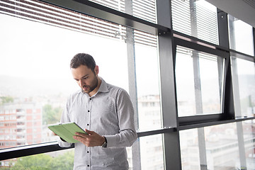 Image showing Businessman Using Tablet In Office Building by window