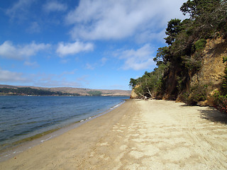 Image showing deserted beach with blue sky and white clouds