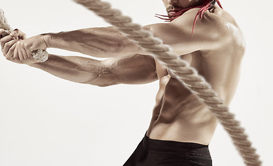 Image showing Attractive muscular man working out with heavy ropes.