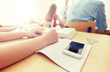 Image showing student with smartphone and notebook at school