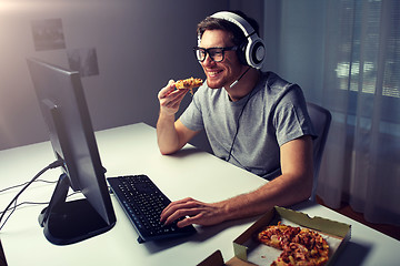 Image showing man in headset playing computer video game at home