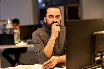 Image showing creative man with computer working at night office