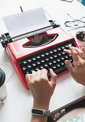 Image showing Woman hand working with bright red vintage typewriter