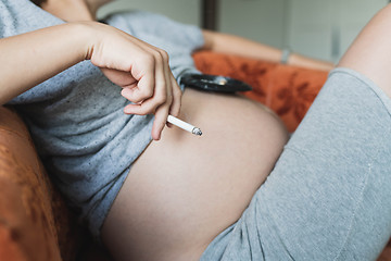 Image showing Pregnant woman smokes a cigarette