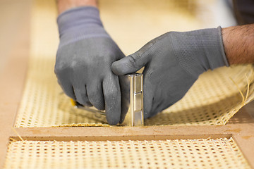 Image showing assembler with staple gun making furniture