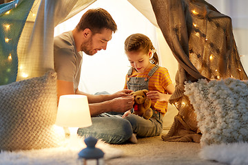 Image showing happy family playing with toy in kids tent at home