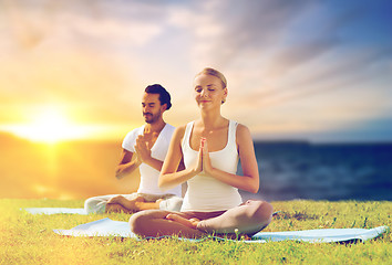 Image showing happy couple making yoga and meditating outdoors