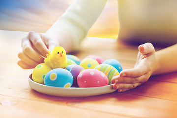 Image showing close up of woman hands with colored easter eggs