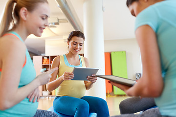 Image showing happy pregnant women with tablet pc in gym