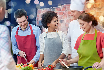 Image showing happy friends and chef cook cooking in kitchen