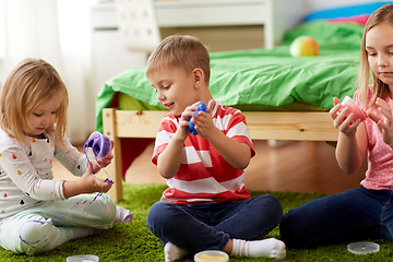 Image showing little kids with modelling clay or slimes at home