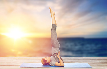 Image showing woman doing yoga in shoulderstand pose on mat