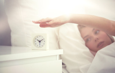 Image showing close up of woman with alarm clock in bed at home