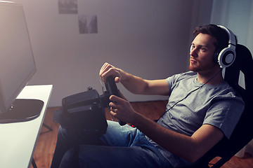 Image showing man playing car racing video game at home