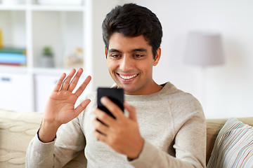 Image showing happy man having video call on smartphone at home