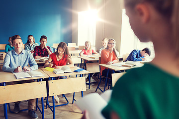 Image showing group of students and girl with notebook at school