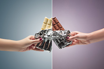 Image showing Hands of a woman holding a tile of chocolate