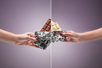 Image showing Hands of a woman holding a tile of chocolate