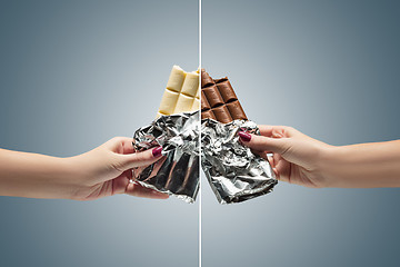 Image showing Hands of a woman holding a tile of chocolate