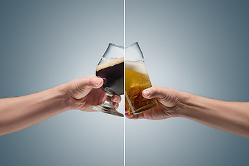 Image showing Closeup of a male hand holding up a glass of beer