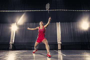 Image showing Young woman playing badminton at gym