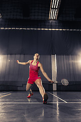 Image showing Young woman playing badminton at gym