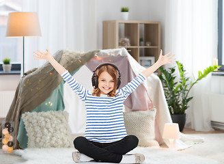 Image showing girl with headphones listening to music at home