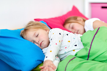 Image showing happy little girls sleeping in bed at home