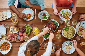 Image showing group of people eating chicken for dinner