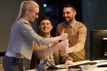 Image showing business team making thumbs up gesture at office