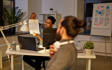 Image showing creative man showing papers to colleague at office