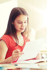 Image showing happy student girl with test paper at school