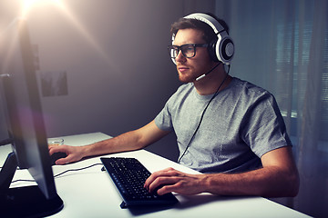 Image showing man in headset playing computer video game at home