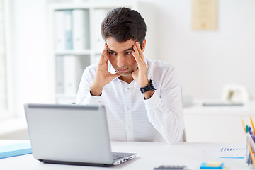 Image showing stressed businessman with laptop at office