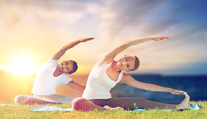 Image showing couple making yoga exercises outdoors