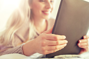 Image showing close up of young woman with tablet pc at home