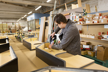 Image showing assembler with screwdriver making furniture