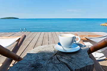 Image showing Wooden floor and sea view with chaise-longues and coffee