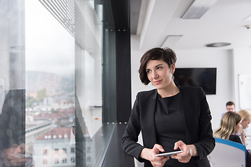 Image showing Elegant Woman Using Mobile Phone by window in office building