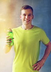 Image showing smiling man with bottle of water in gym