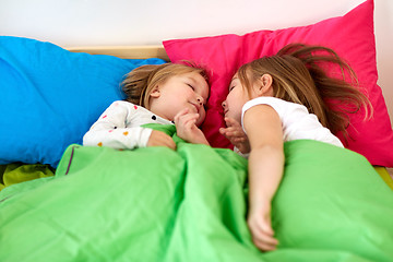 Image showing happy little girls sleeping in bed at home