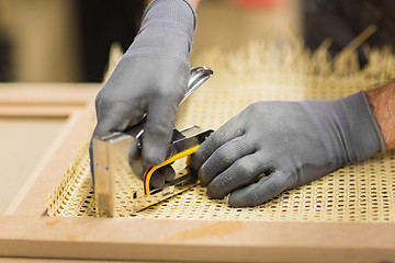 Image showing assembler with staple gun making furniture